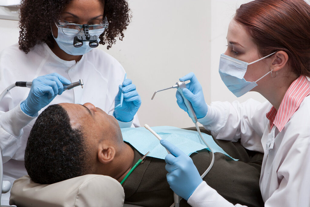 Dental team cleaning patient's teeth